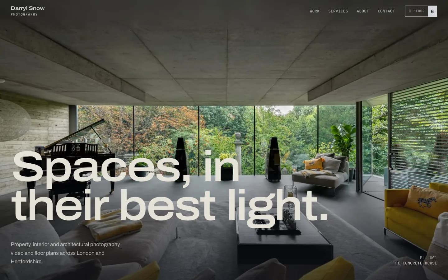 Home page hero: a board-marked concrete living room with a grand piano and a glass wall onto woodland, under the headline 'Spaces, in their best light.'